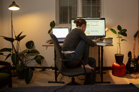 Woman working late night home office from apartment