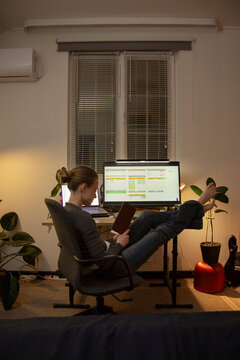Woman reading book relaxing working from home at night