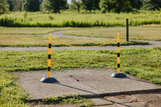 Yellow and black safety posts with chain on pavement