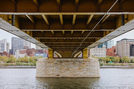 Exploring the Architecture Beneath a City Bridge on a Calm River