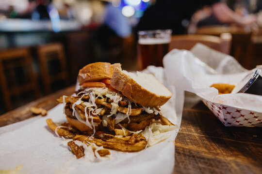 Heaping Sandwich With Fries Served in a Casual Restaurant Setting