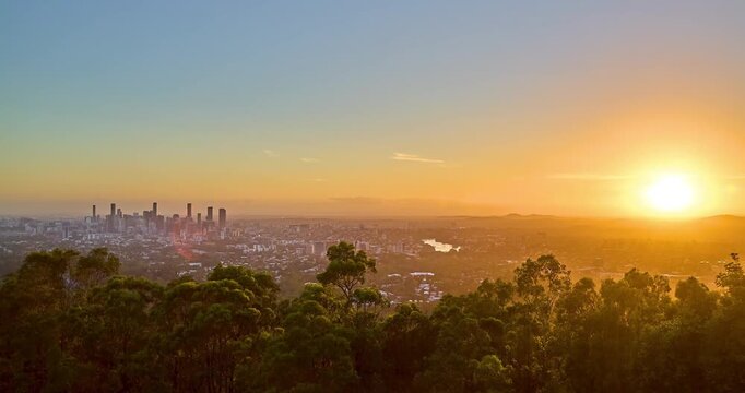 4k Locked down Time Lapse motion of sunrise of sun rising from the horizon into the clear morning sky with the Brisbane City CBD in foreground, Brisbane, Queensland, Australia