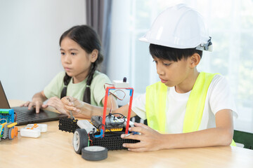 Kids boy and girl working together on robotics project, combining programming, engineering skills, promoting STEM education, teamwork, creativity, learning for future innovation.