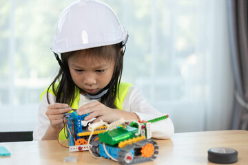 Focused young girl wearing hard hat and safety vest building a robotic vehicle, symbolizing STEM education, innovation and hands on learning in engineering and technology for kids.