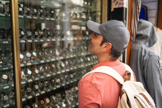 Man looking at watch shop window