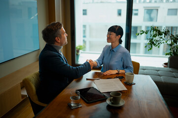 Business professionals shaking hands completing a deal

