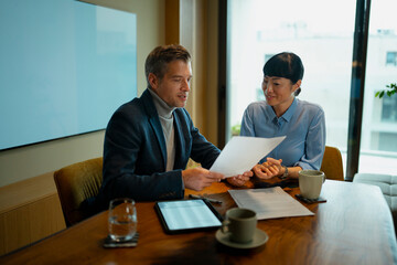 Business colleagues collaborating on documents during office meeting
