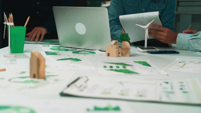 A team collaborates in a modern office, analyzing strategies for sustainable development. They utilize eco-friendly materials and innovative designs for effective planning. SACTR