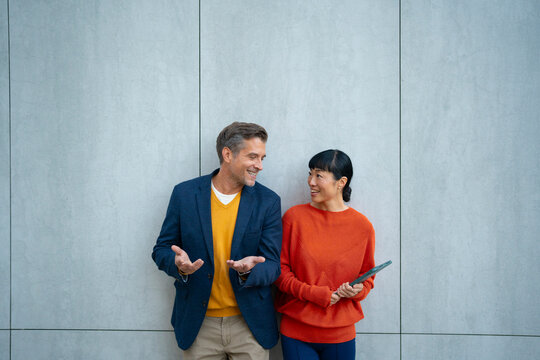 Diverse colleagues having cheerful conversation, collaborating outdoor