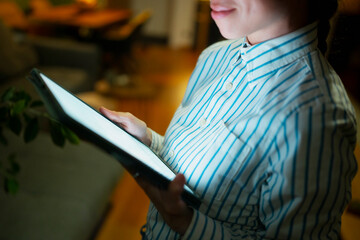 Woman reading digital book on tablet at night
