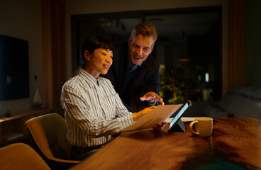 Business colleagues collaborating on digital tablet at night
