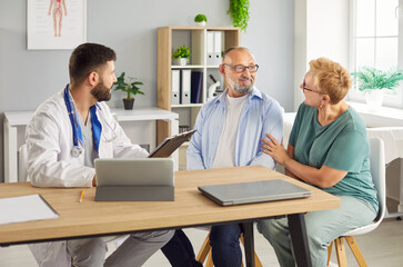 Obraz premium Doctor consultation reviews medical records with elderly couple in clinic, covers test results for health. Senior mature patients discussing treatment with physician. Medicine concept. 