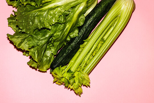 Green vegetables on a pink surface