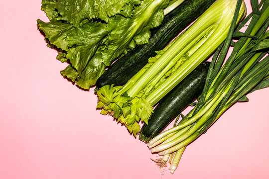 Green vegetables on a pink surface