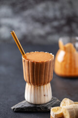 Trending cold drink banana coffee in a glass on the table