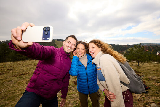 Friends snapping selfies on a mountain hike