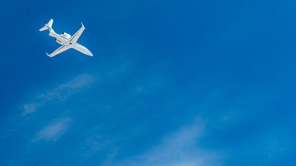 Business jet flying high in blue sky