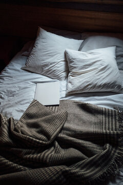 Cosy bed with a book on lying in the middle