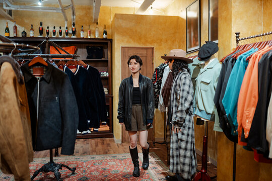 Shop assistant helping female customer in fashion boutique in Japan