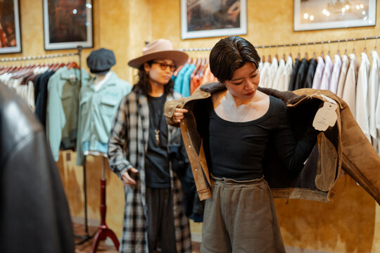 Woman trying on jacket in Japanese clothing store