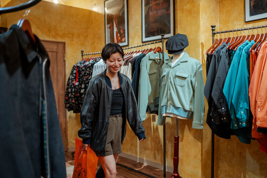 Woman enjoying shopping for vintage clothing in Osaka boutique