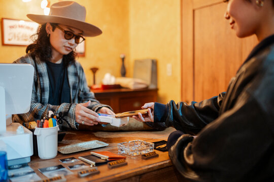 Customer making mobile payment at retail store cash register - Powered by Adobe