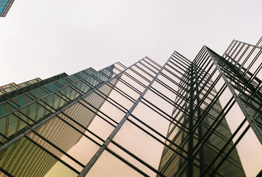 Modern glass skyscraper reflecting city architecture
