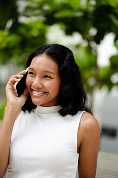 Happy Woman Talking on Phone Outdoors and Smiling 