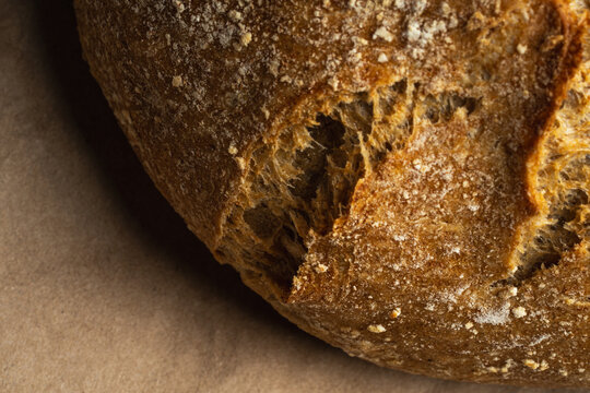 Crusty round artisan bread on brown paper