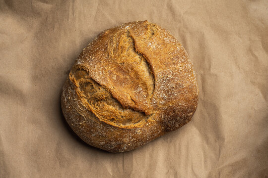 Whole artisan bread loaf on brown paper
