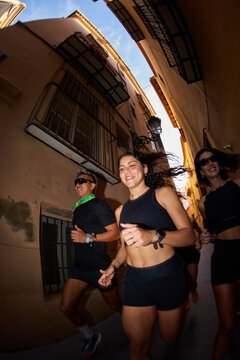 Group of runners enjoying the morning in narrow city streets