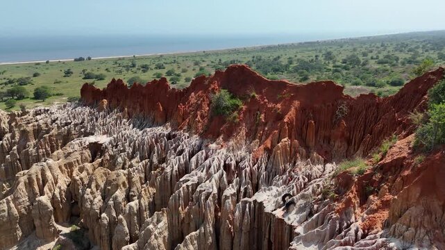 Cinematic drone perspective of the vibrant red clay cliffs at Miradouro da Lua (Viewpoint of the Moon) in Belas Municipality, Luanda Province, Angola, Africa