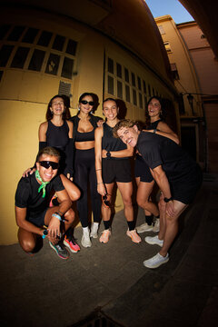 Group of friends posing for a fun photo in a narrow street