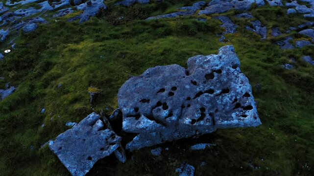 Top-down aerial view of the limestone capstone of Poulnabrone Dolmen in late evening light after sunset in Ireland