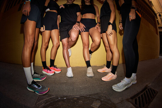 Group of runners posing in urban setting during evening hours