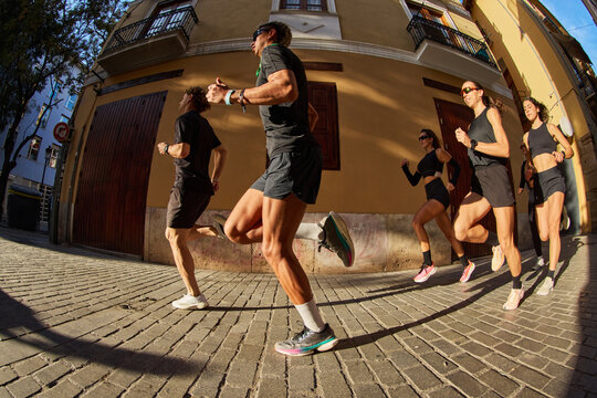 Group jogging along a sunlit street in the city