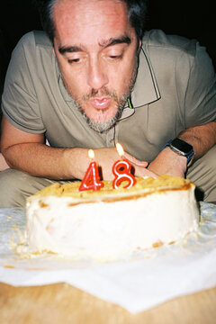 Man Blowing Out Candles
