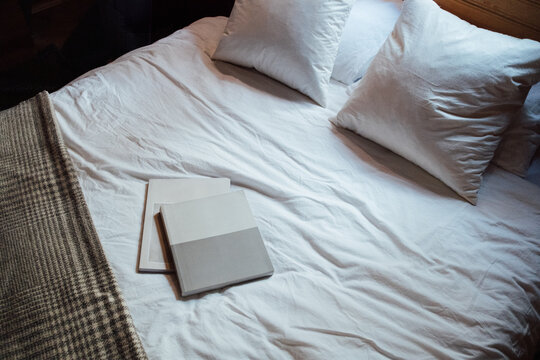 Top View of Bed With Two Books On Top of It
