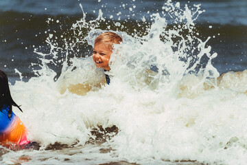 Children enjoy splashing in ocean waves at beach