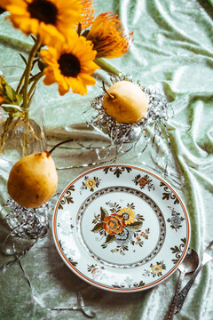 Sunflowers and fruit on a patterned plate setting