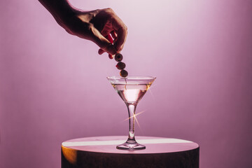 Elegant Martini Moment with Olives Against Soft Pink Cocktail Backdrop