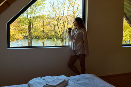Woman enjoys coffee by the window
