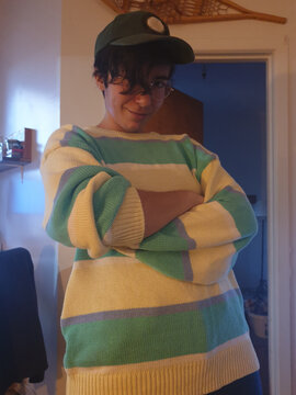 Androgynous woman with short hair and green cap