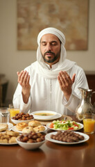 Middle eastern adult male in traditional clothing praying over festive meal