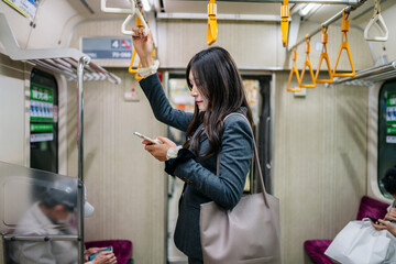 Japanese business woman commuting and using smartphone on train