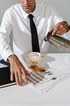 Man accidentally spilling coffee on financial documents