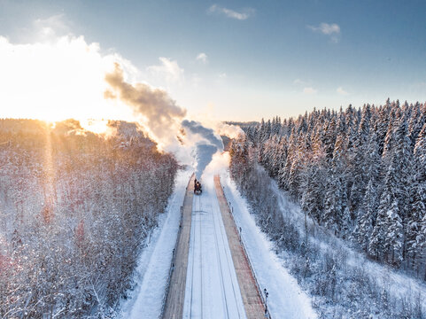 Retro steam Train Traveling Through a Snowy Forest During Winter