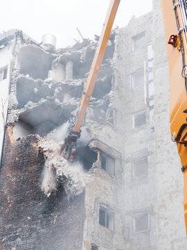 Building demolition in urban area with heavy machinery at work