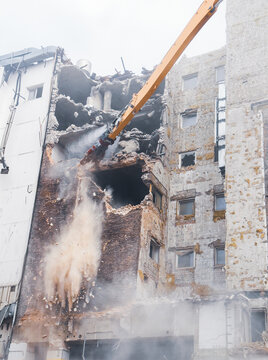 Building demolition in urban area with heavy machinery at work