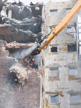 Building demolition in urban area with heavy machinery at work